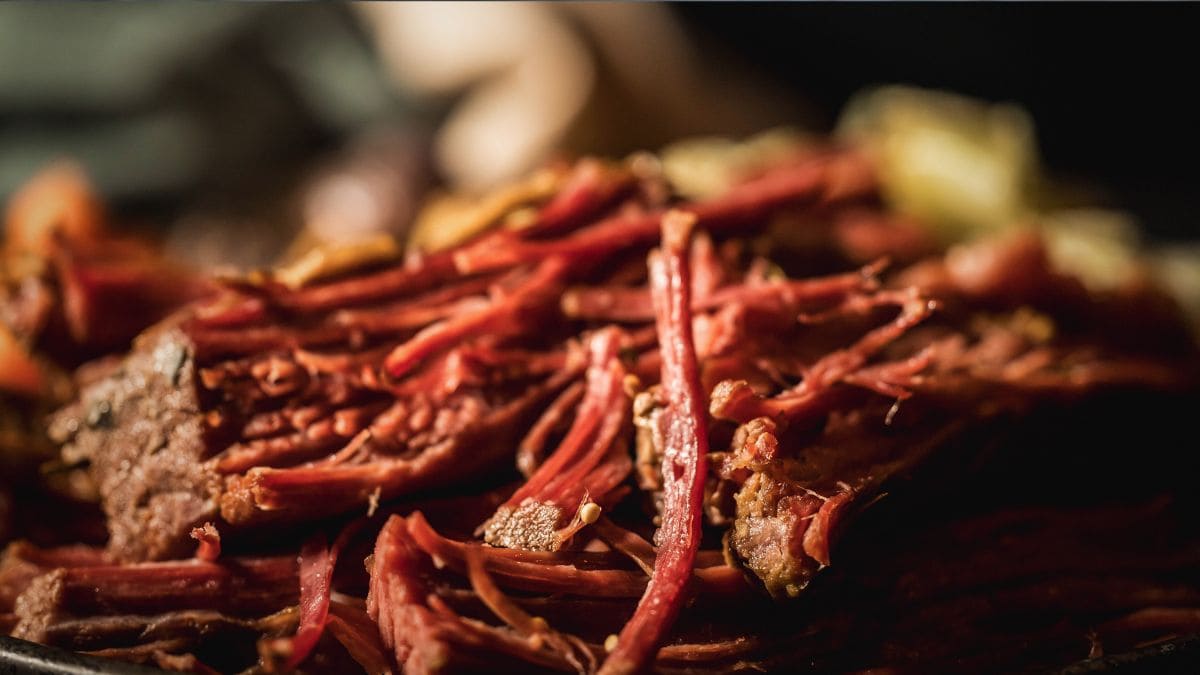 Close-up of tender shredded corned venison with rich color and juicy texture, perfect for showcasing proper cooking technique.