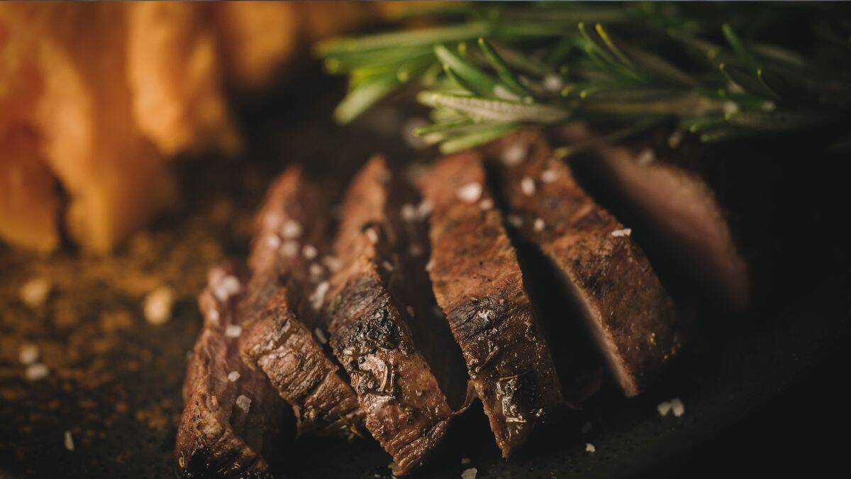 Sliced venison backstrap seared to perfection with salt and rosemary, showcasing ideal doneness for tender cuts.