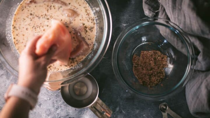 Chicken is placed in a seasoned, buttermilk brine for making a southern fried chicken recipe.