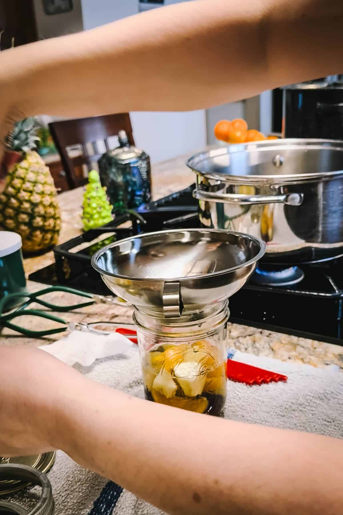 Packing a jar with mixed fruit for canning fruit cocktail