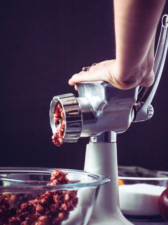 Grinding cranberries in a hand cranked grinder to make cranberry jello salad