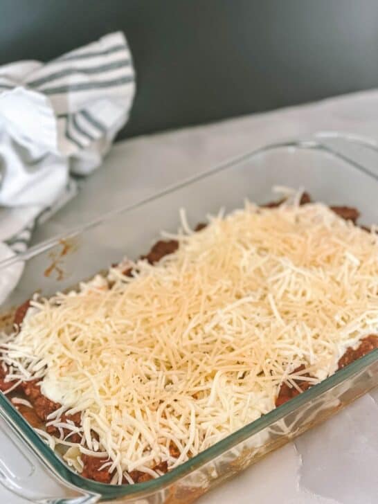 Lasagna being assembled in a pan for the oven