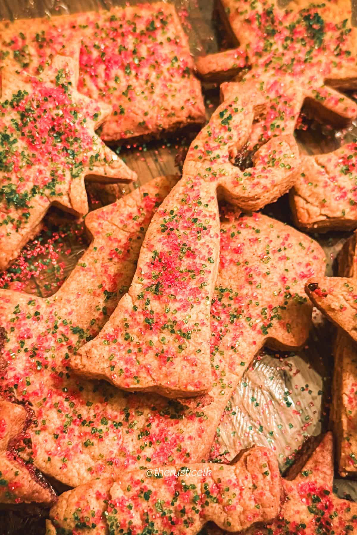 Freshly baked St. Nicholas speculaas cookies topped with red and green sugar on a festive platter.