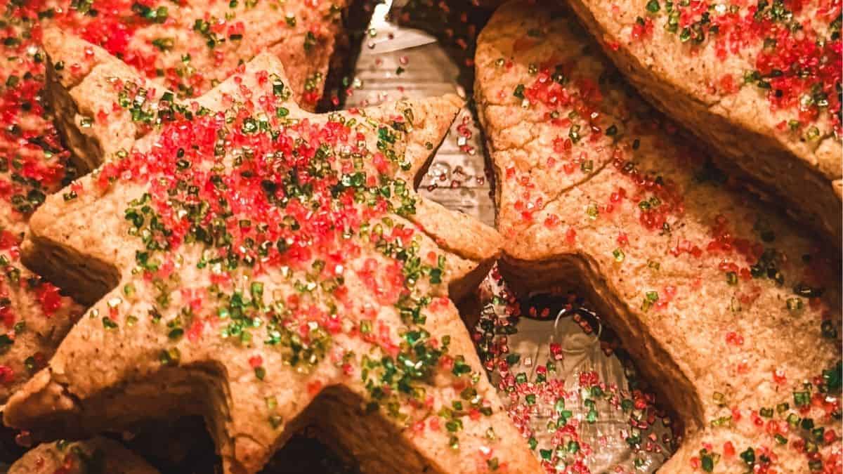 Close-up of spiced St. Nicholas speculaas cookies topped with red and green sugar, showing their crisp texture.