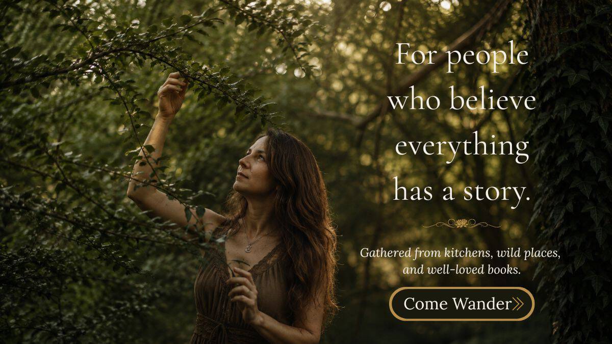 Elle McCoy, author of The Rustic Elk, in an earthy linen dress reaching toward tree branches in a sunlit forest, surrounded by lush greenery.