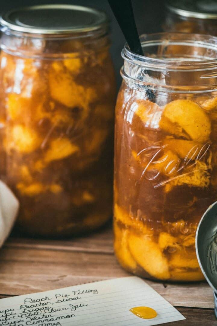 Стеклянные банки с персиковой начинкой для пирогов на деревянном столе