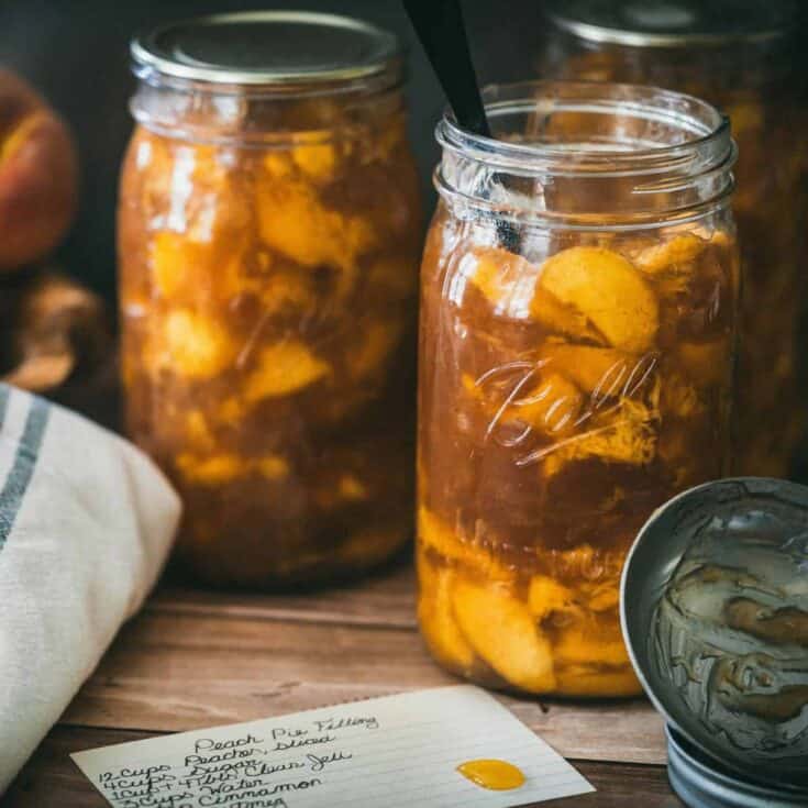 Homemade canned peach pie filling in Ball mason jars made with fresh peaches, Clear Jel, cinnamon, and vanilla using a safe water bath canning recipe.